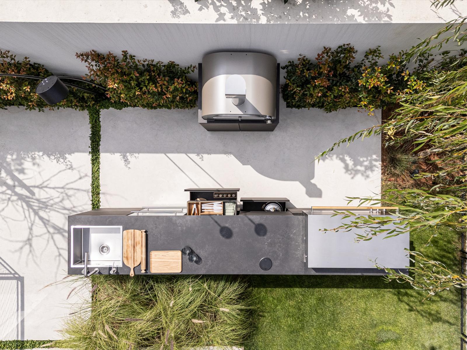 Aerial view of a large UNICA outdoor kitchen island with grill, sink and pizza oven